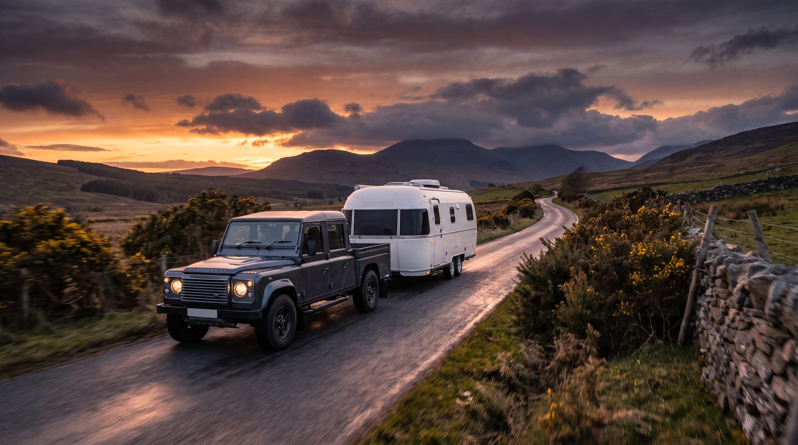 Pickup truck towing a white touring caravan away along a rural Scottish road